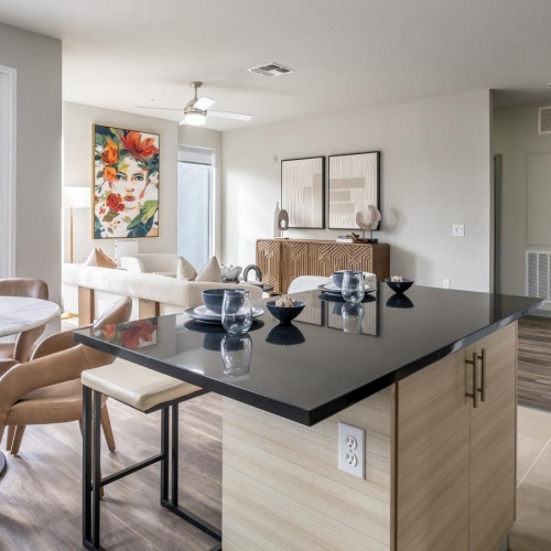 Generous living spaces with beautiful natural lighting a kitchen with a bar and chairs