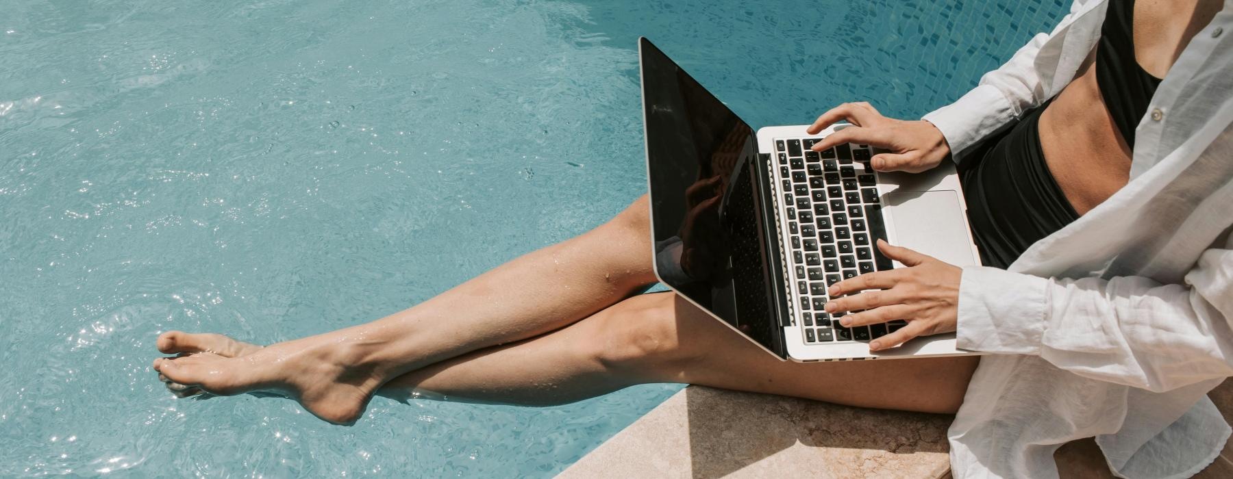 a person using a laptop near pool